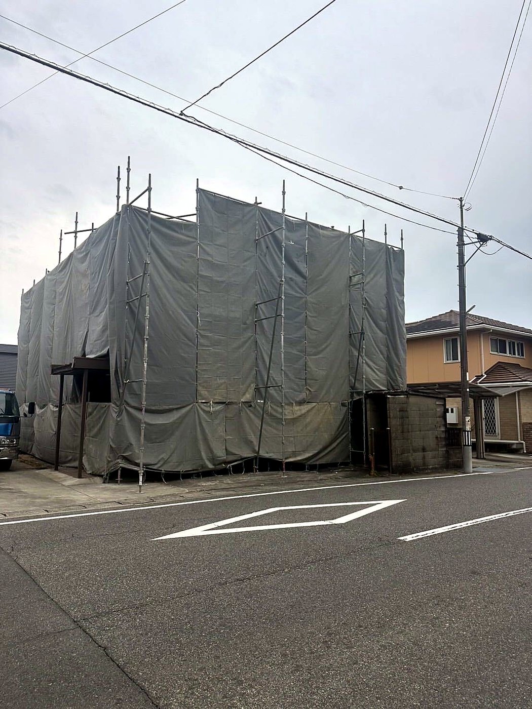 解体前の建物(足場養生シートで覆われた家屋)